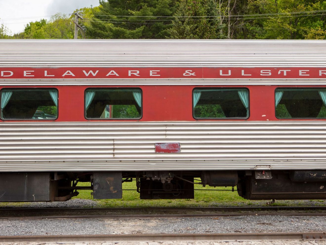 Side view of a Delaware & Ulster train car with red and grey colors.